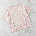 Pastel pink tie-dye t-shirt laid flat on marble surface